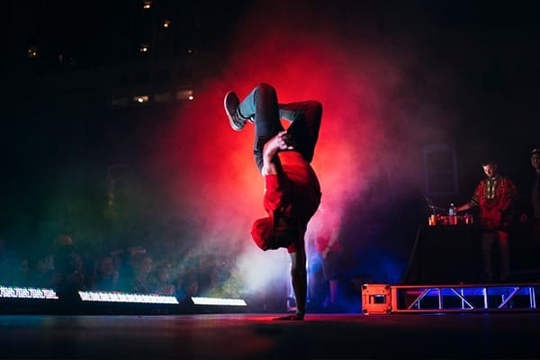 JC Pro - a young man doing a full handstand at a concert for a crowd